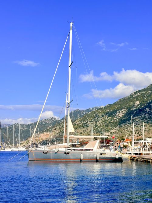 Free Scenic view of a sailing yacht docked at Kastellorizo harbor, Greece with clear blue skies. Stock Photo