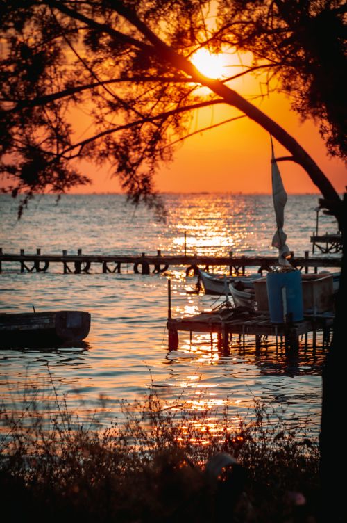 Free Captivating sunset over the sea in Thessaloniki with boats and docks silhouetted against the vibrant sky. Stock Photo