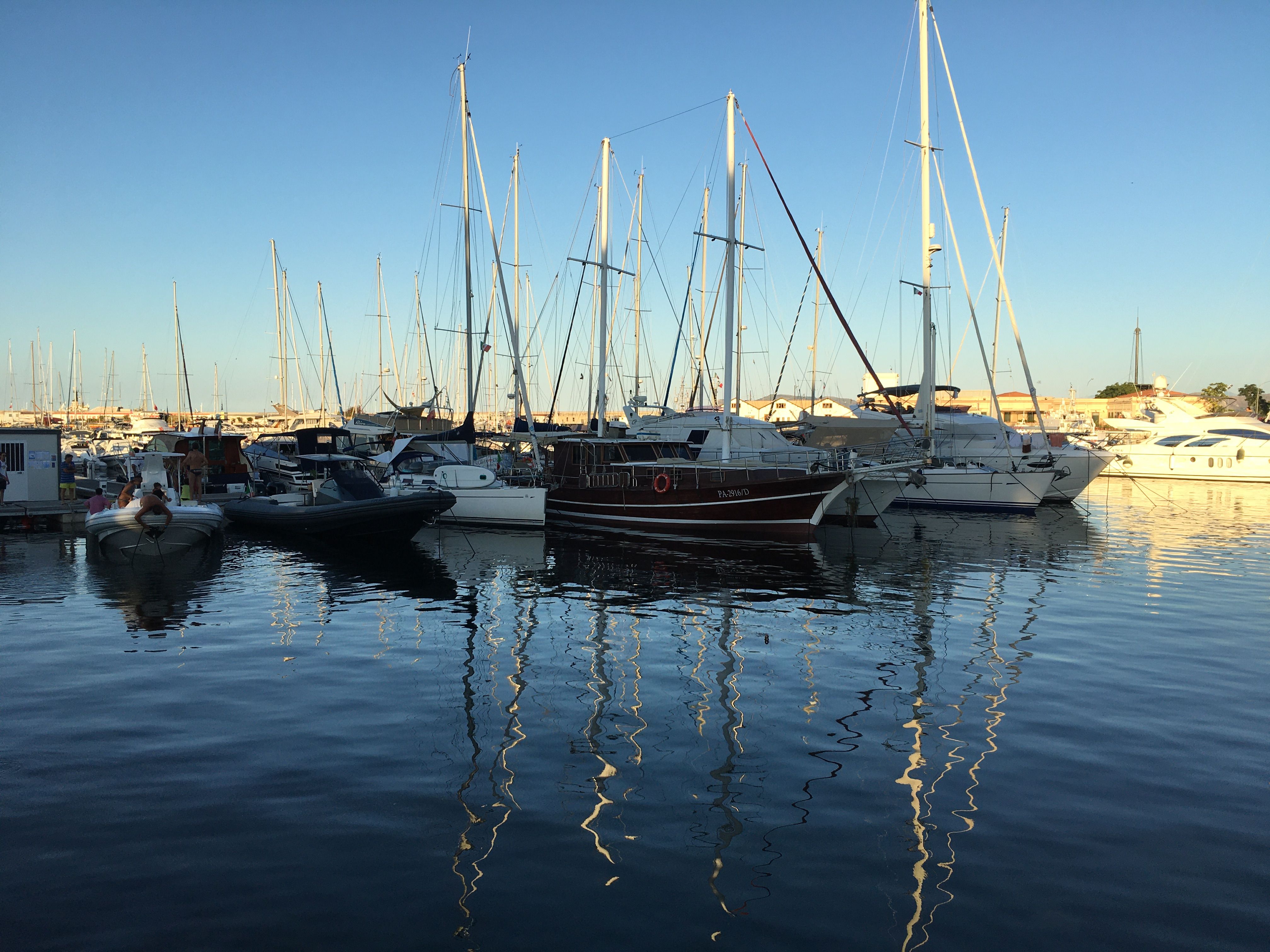 Peaceful scene of boats docked at Palermo marina during a clear day.