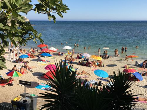 Free Lively seaside scene with sunbathers and colorful umbrellas on Poetto Beach, Sardinia. Stock Photo