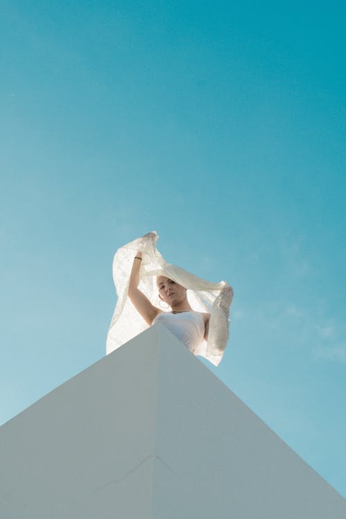 Low Angle Shot on Woman Under Blue Sky