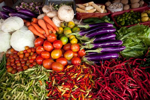 Vibrant selection of fresh vegetables arranged at an outdoor market stall.