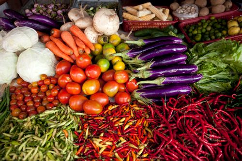 Free Vibrant selection of fresh vegetables arranged at an outdoor market stall. Stock Photo