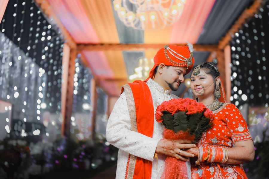 Couple celebrating their wedding under a decorated mandap