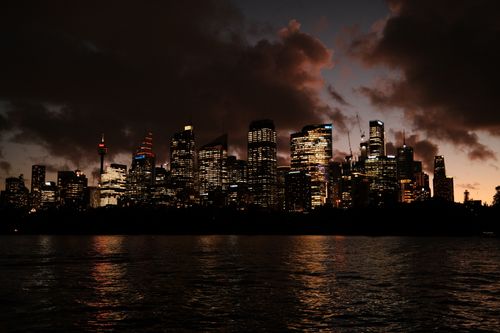 Free Stunning twilight view of Sydney's illuminated skyline reflecting on the water. Stock Photo