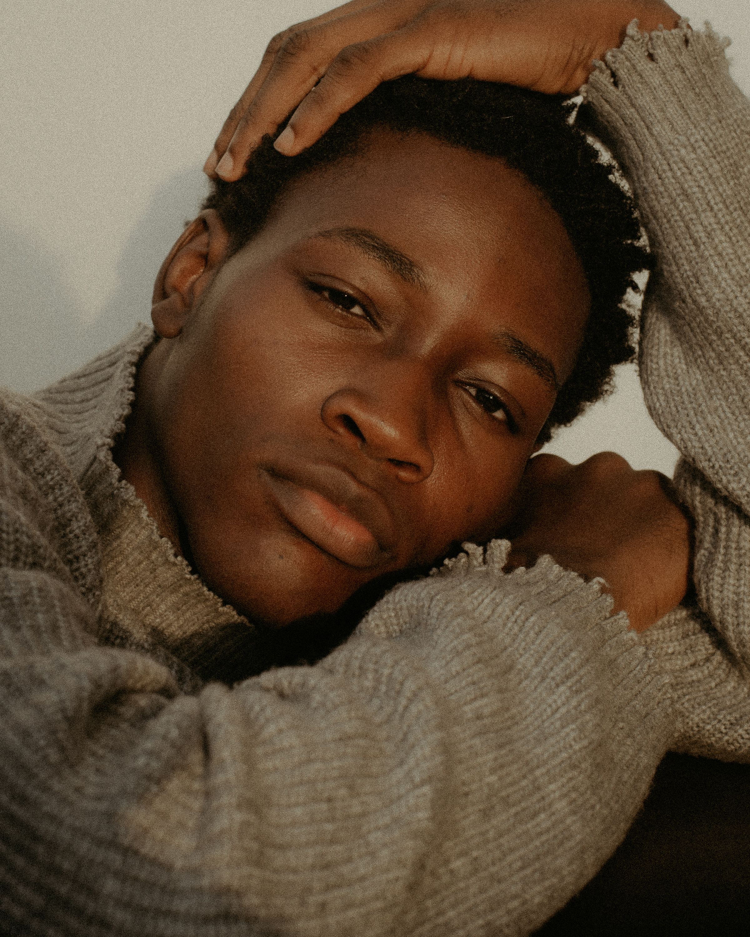 Moody portrait of a young man in Lagos, Nigeria, showcasing thoughtful expression and natural lighting.