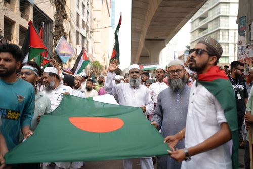 Free A street protest in Dhaka featuring participants holding the Bangladesh flag. Stock Photo