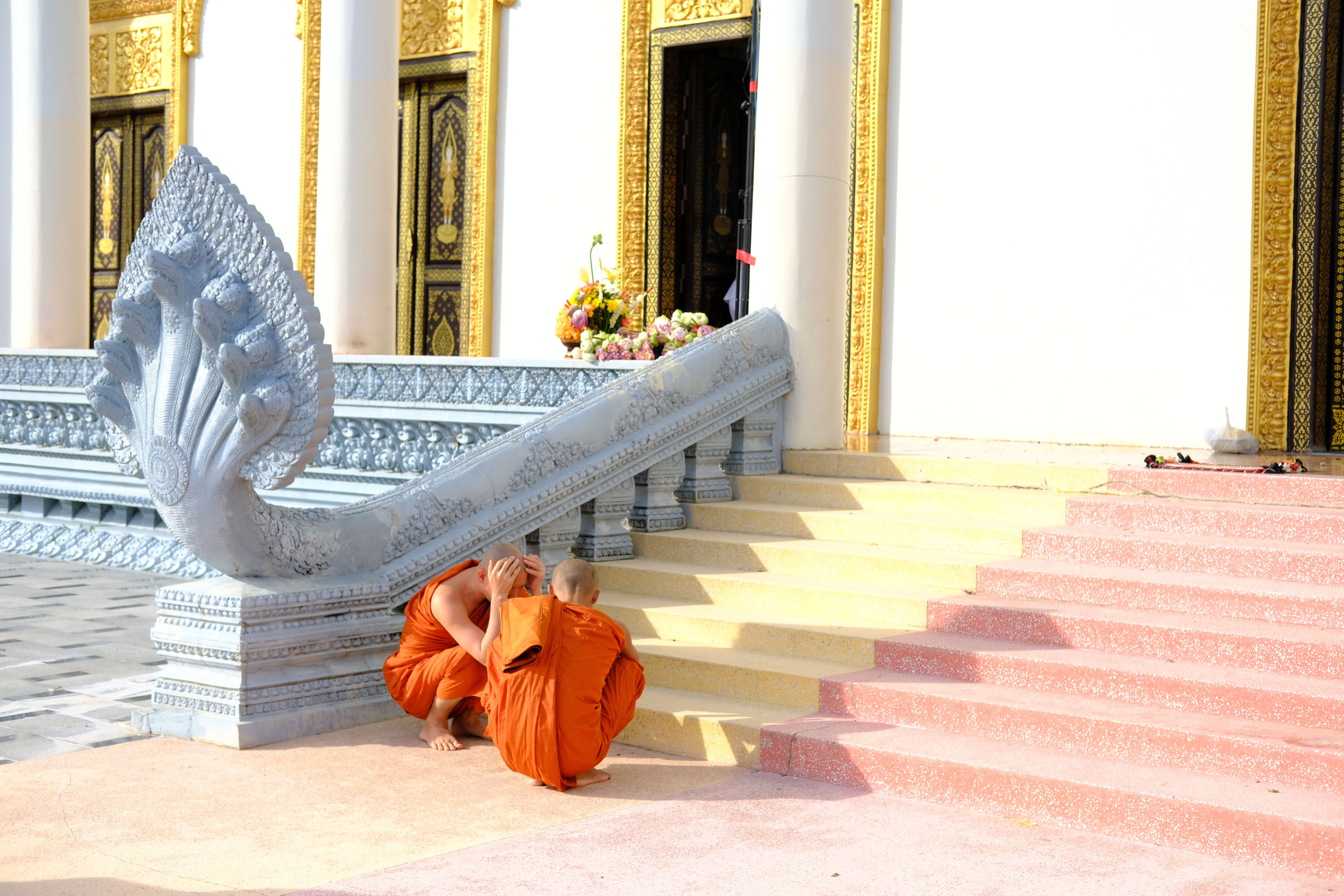 Cambodian Buddhist monk walking past golden temple pagoda 1