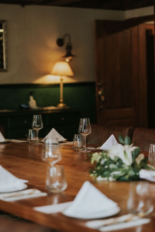 Free Warm and inviting dining room with elegantly set table, featuring glassware and folded napkins. Stock Photo