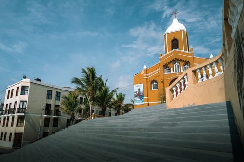 Free Vibrant church exterior in sunny Pacasmayo, Peru, featuring a staircase leading towards it. Stock Photo