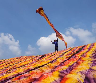 A vibrant display of traditional batik fabric drying under the sun in Sukoharjo, Indonesia.