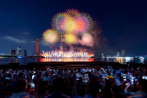 Free Captivating fireworks display lighting up the night sky above a bustling city waterfront. Stock Photo