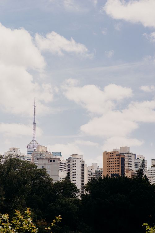 Free A view of São Paulo's skyline featuring modern skyscrapers under a bright blue sky with clouds. Stock Photo