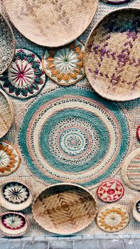 Artistic wall display featuring various colorful woven baskets.