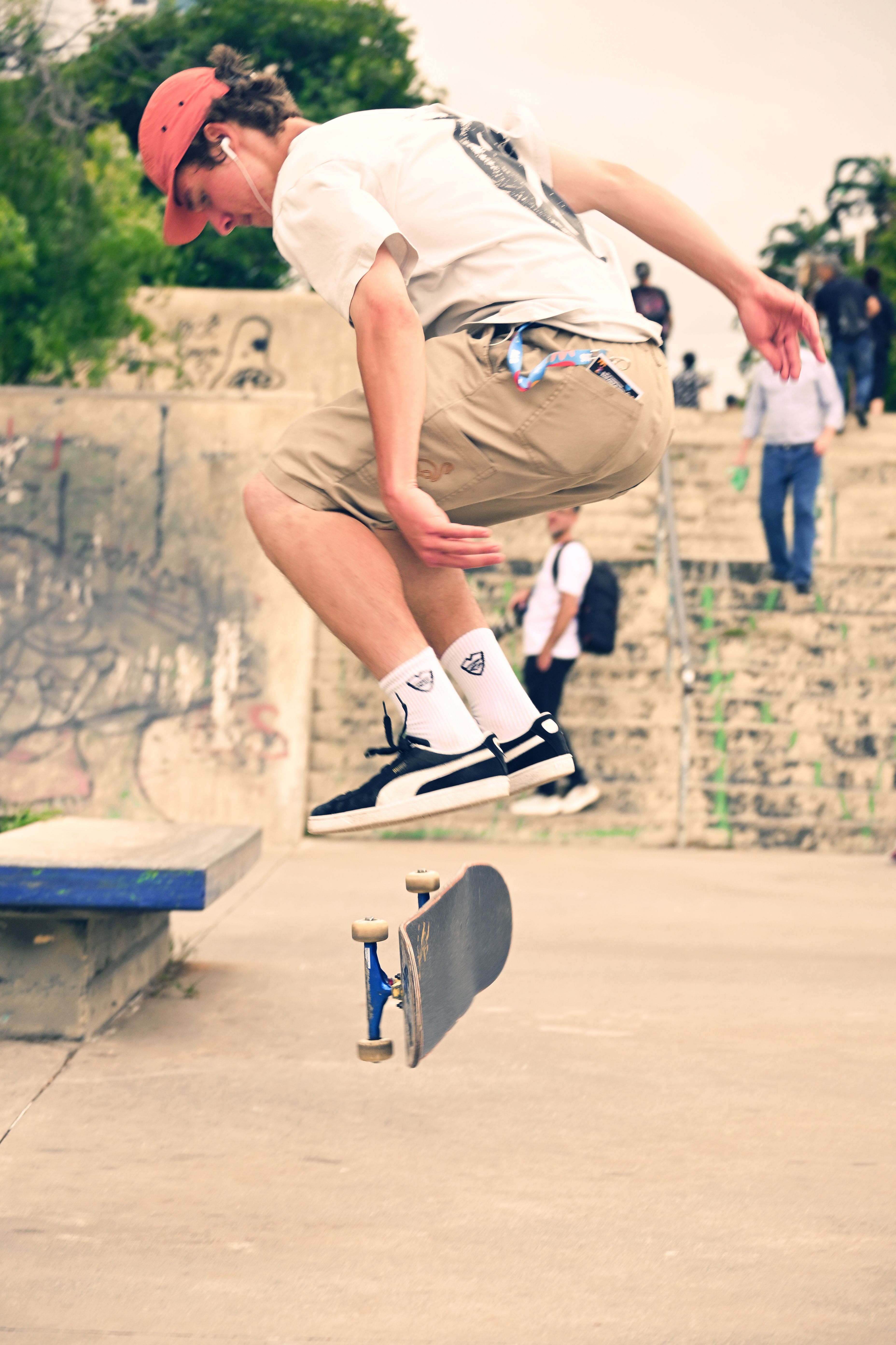 Dynamic shot of a young skater mid-air performing a trick at a bustling urban skate park.. pexels, dynamic, shot