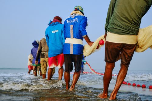 Free Fishermen at Cox's Bazar beach pulling nets at sunrise, showcasing traditional fishing techniques. Stock Photo