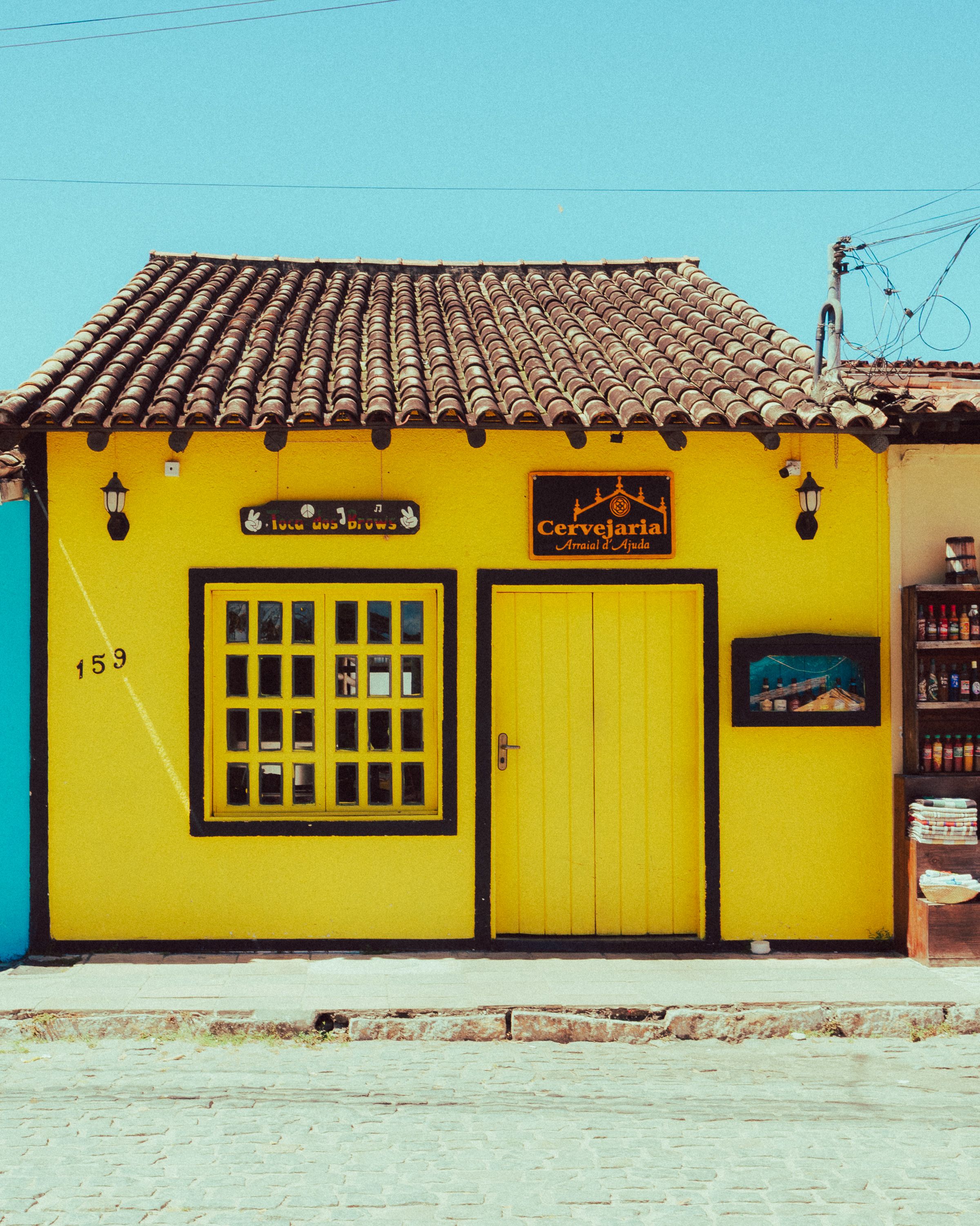 Vibrant Yellow Storefront in Cobblestone Street · Free Stock Photo