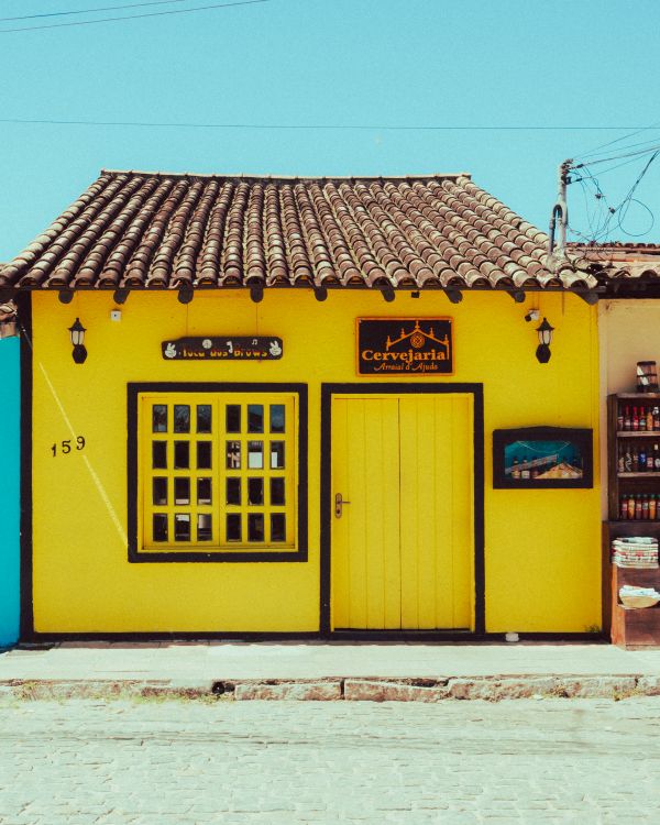Yellow Store Design Vibrant Yellow Storefront in Cobblestone Street · Free Stock Photo