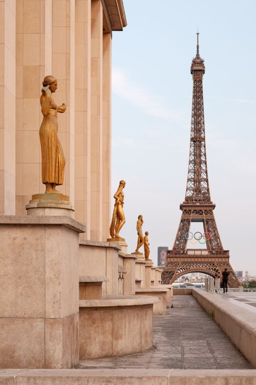 Free View of the Eiffel Tower framed by golden sculptures at Trocadéro in Paris, France. Stock Photo
