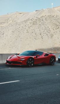 Stylish red sports car parked on a mountain road, showcasing automotive elegance and power.