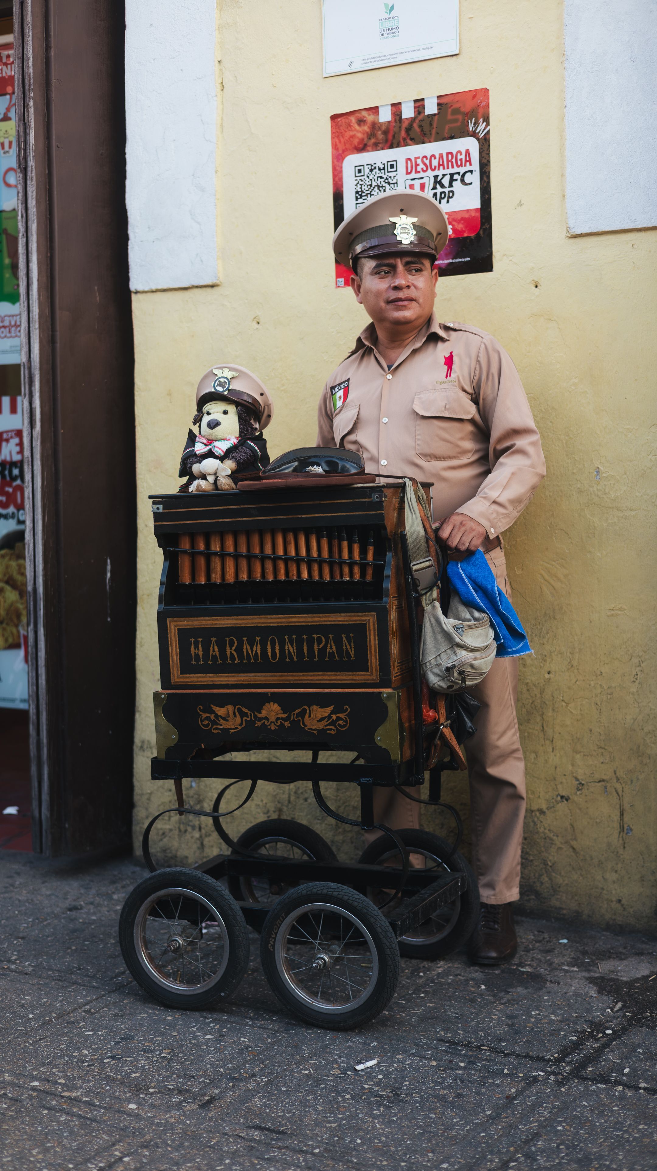 A street performer plays a vintage harmonipan in a vibrant urban setting.