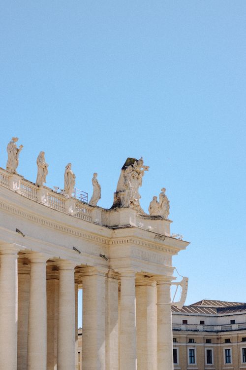 Free Detailed view of St. Peter's Basilica with sculptures under a clear sky in Rome. Stock Photo