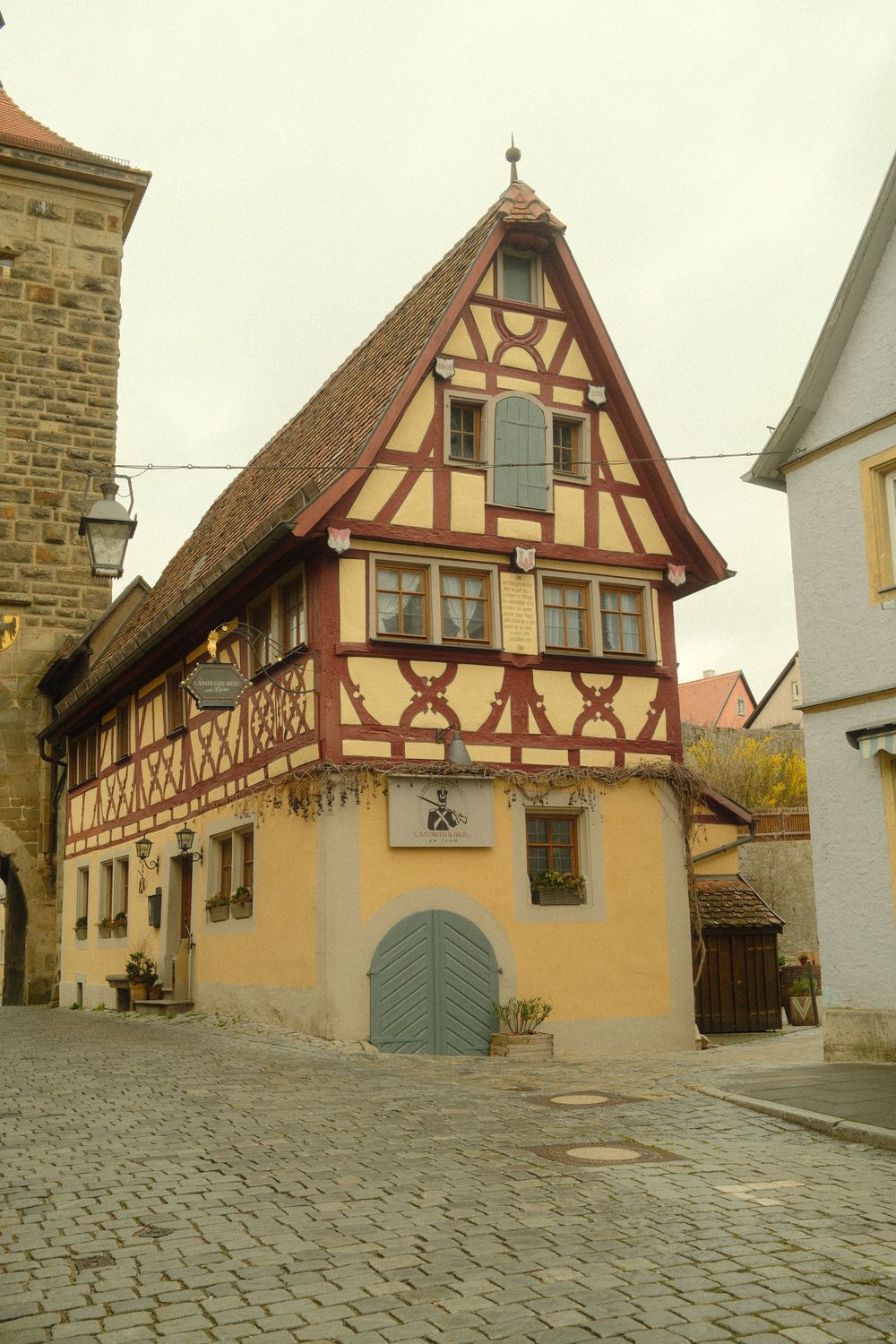 Căsuță cu structură de lemn pe o stradă pavată din Rothenburg