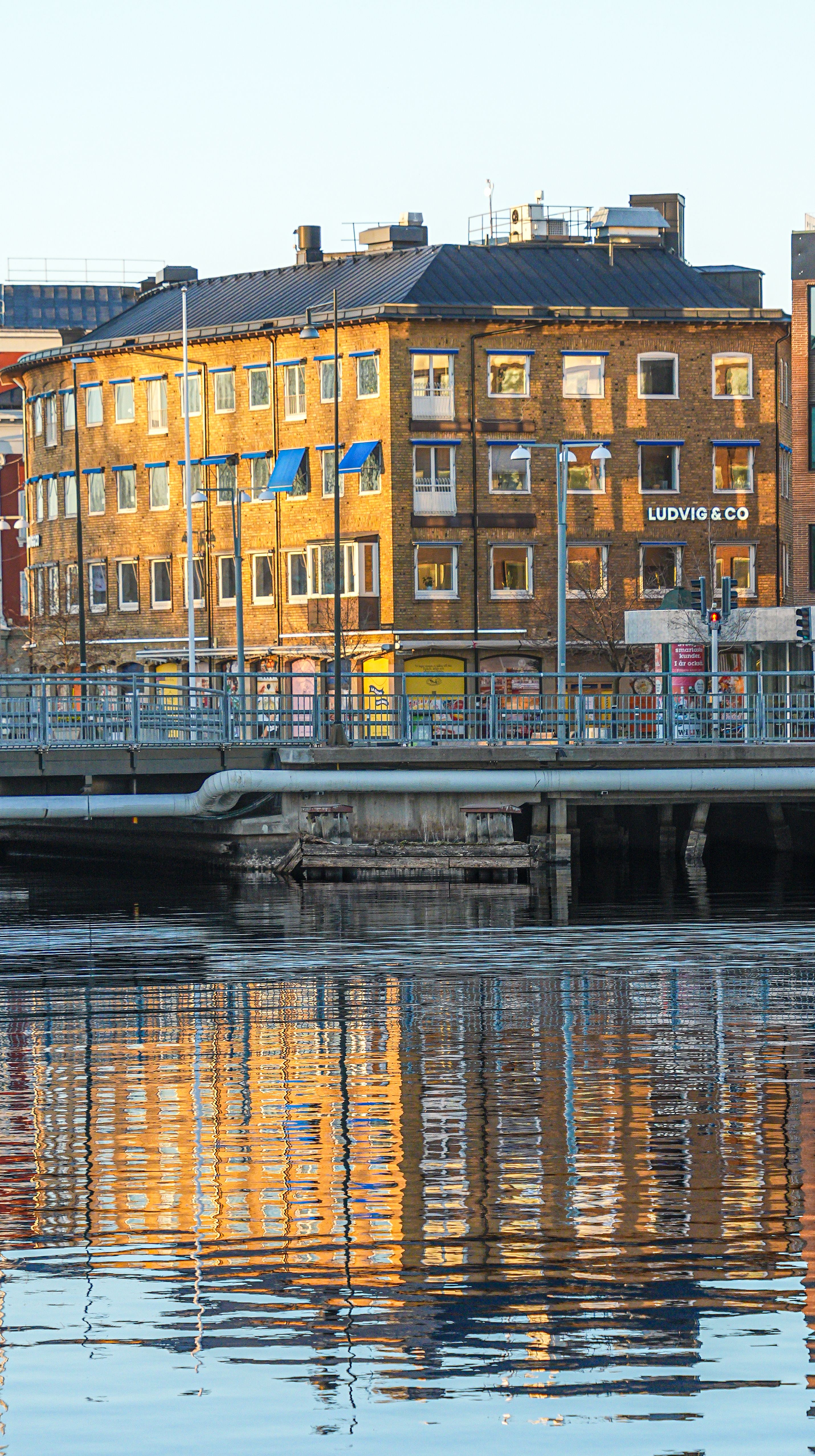 Sunlit building reflecting in water in Jönköping, Sweden's vibrant city landscape.