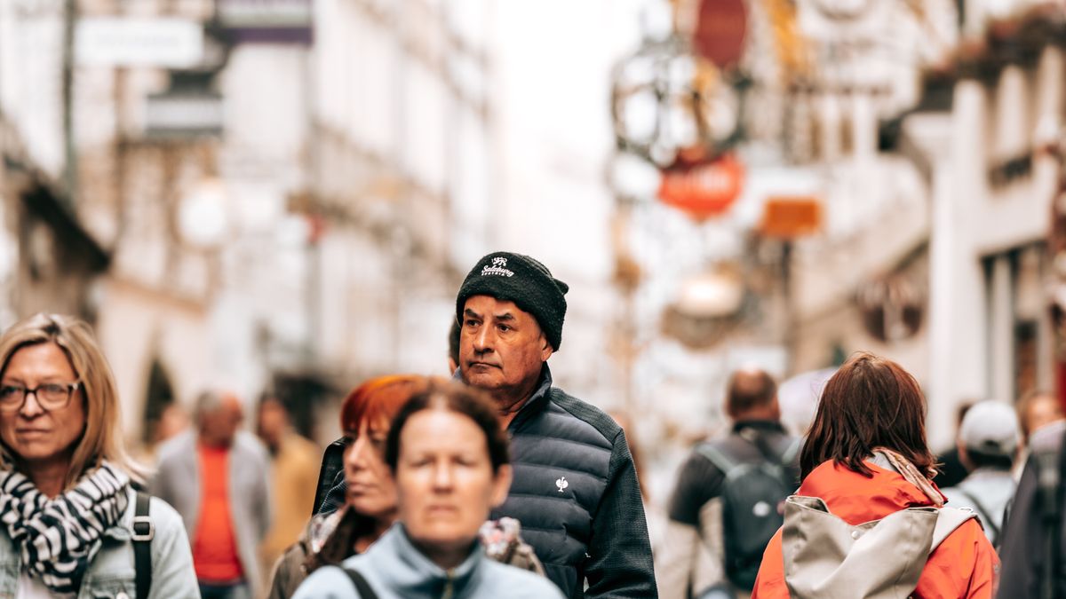 A dense crowd of tourists filling a narrow street in a major European city