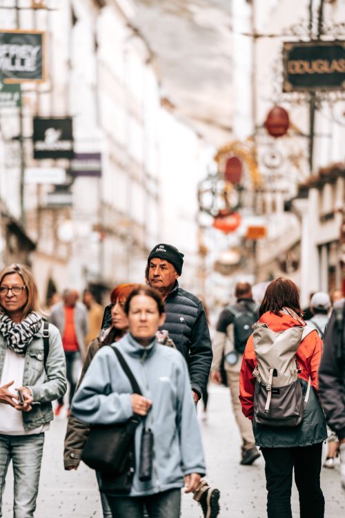 Free A bustling European street scene with tourists in winter clothing, capturing urban life. Stock Photo