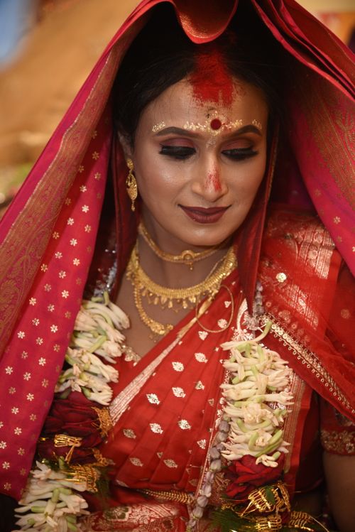 Free Beautiful portrait of a traditional Indian bride in red attire with ornate jewelry. Stock Photo
