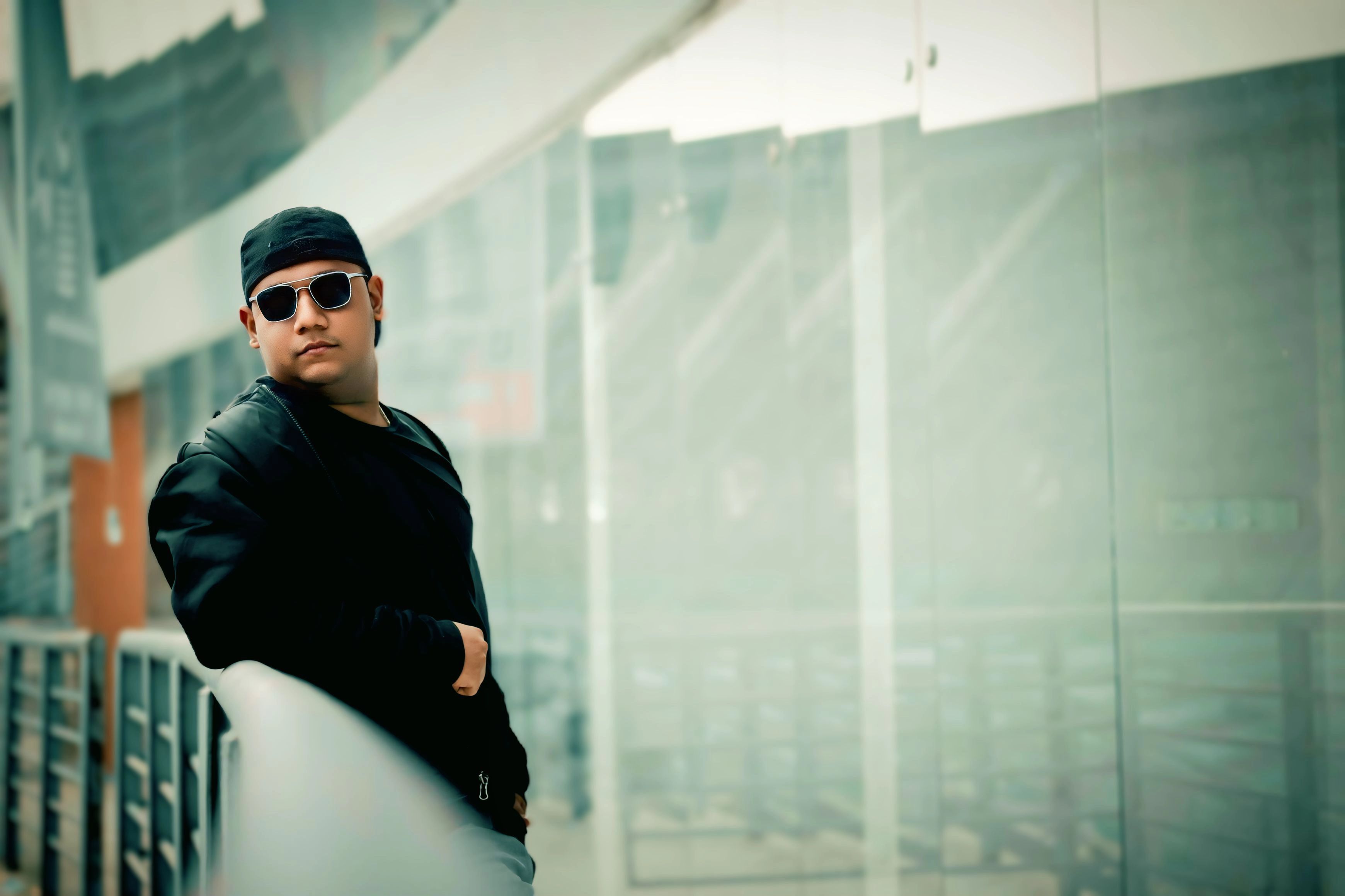 Hip young man in sunglasses posing in a modern urban environment.