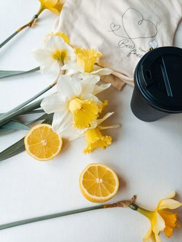Artistic flat lay of daffodils, lemon slices, and coffee creating a bright, refreshing vibe.