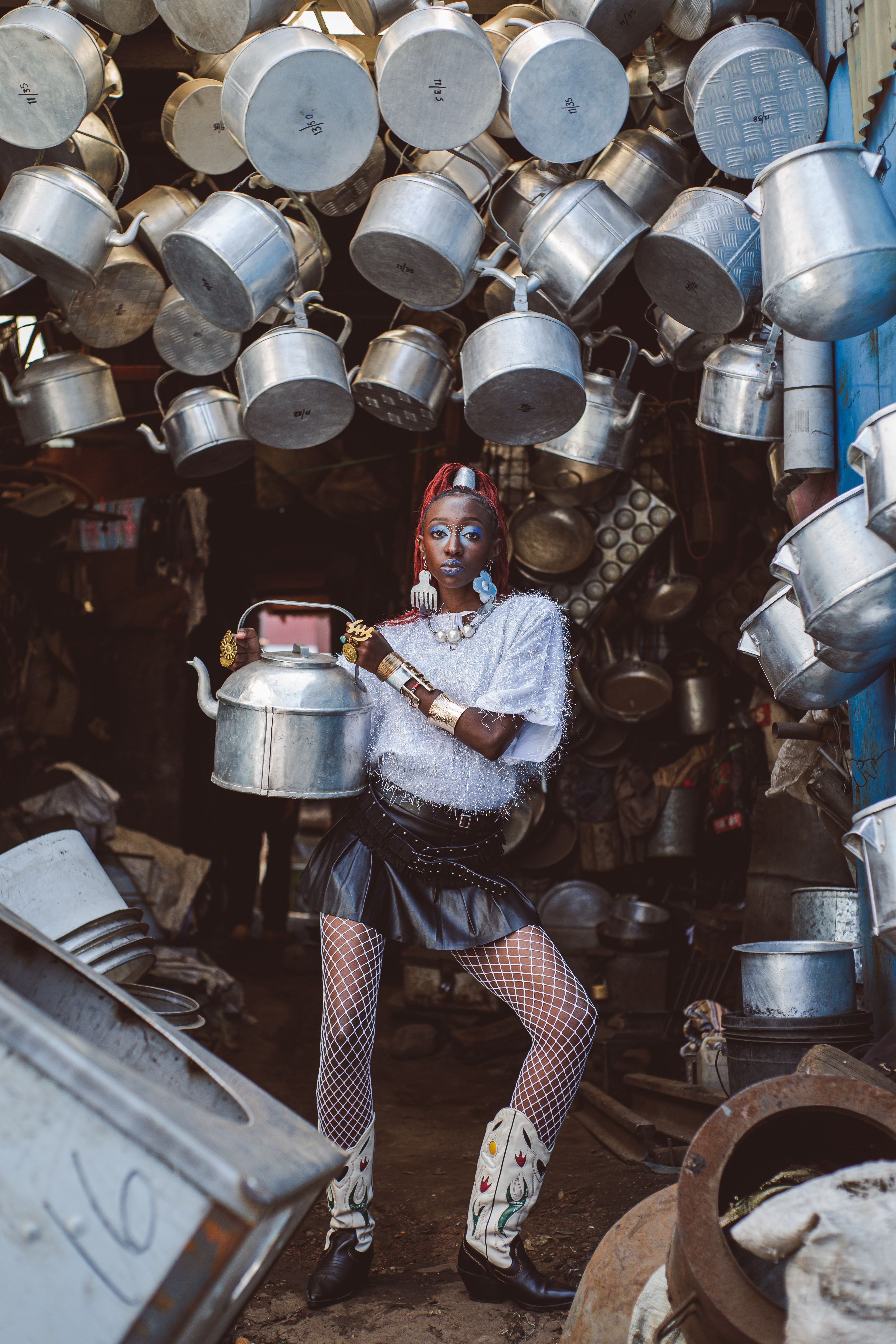 Bold fashion statement amidst hanging pots in Nairobi's vibrant market.