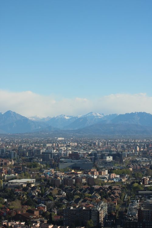 Free Aerial view of Milan showcasing urban landscape with distant Alps on a clear day. Stock Photo