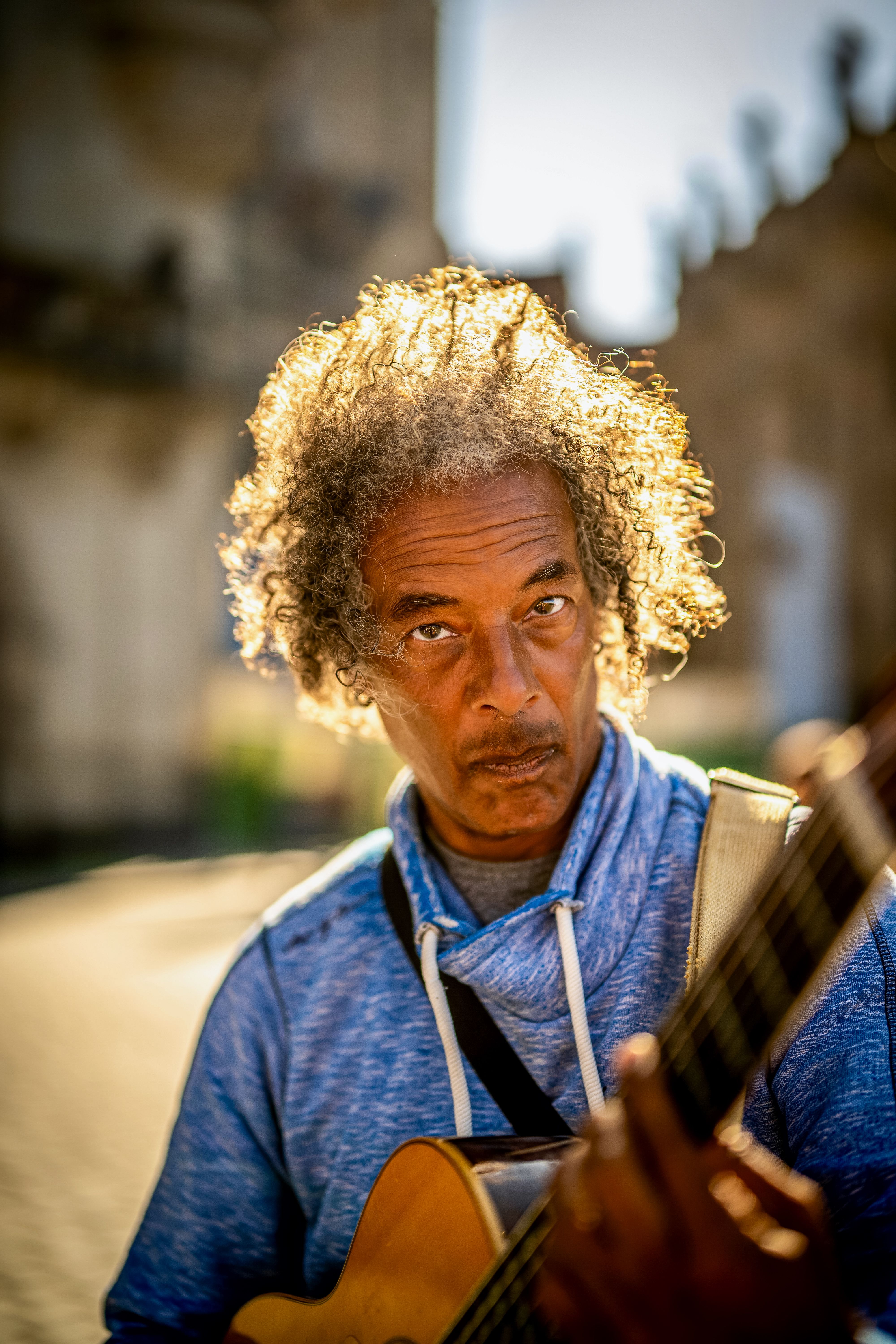 Engaging portrait of a musician playing guitar on a sunny day in Dresden, Germany.