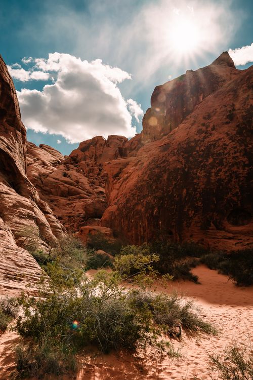 Free Dramatic sunlit view of red rock formations in Moapa Valley, Nevada, showcasing clear skies and desert vegetation. Stock Photo