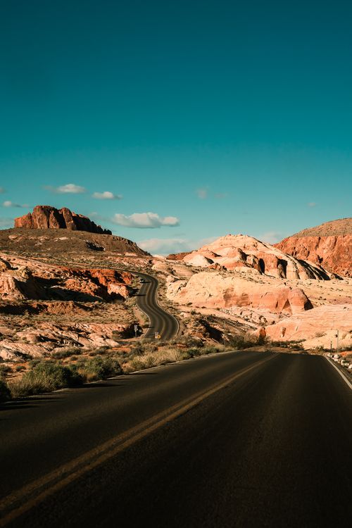 Free Winding road through the vibrant desert landscape of Moapa Valley, Nevada, under a clear blue sky. Stock Photo