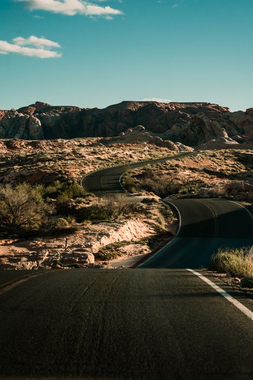Free Winding road through the desert landscape of Moapa Valley, Nevada, under a clear blue sky. Stock Photo