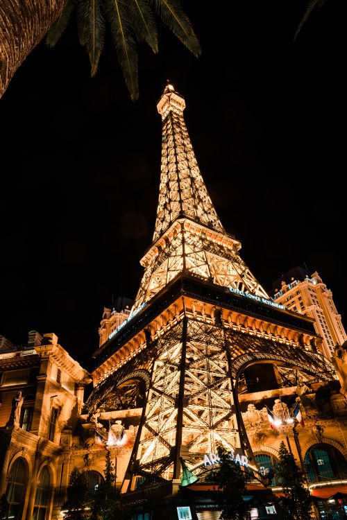 Free Illuminated Eiffel Tower replica at Paris Las Vegas Hotel at night, showcasing dazzling lights and architecture. Stock Photo