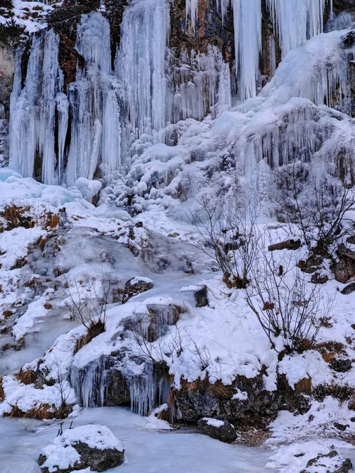 Free Stunning frozen waterfall surrounded by snow and ice, capturing the essence of winter. Stock Photo