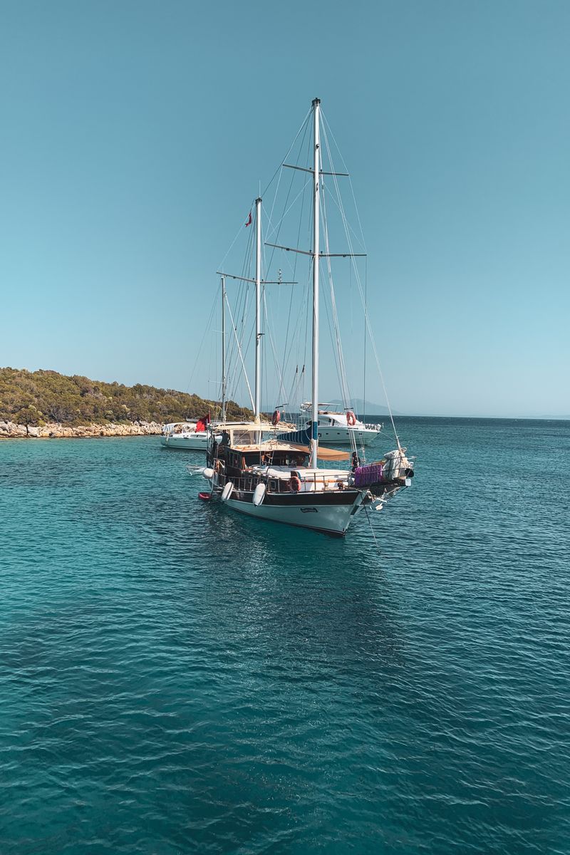 Serene view of sailing boats anchored in Bodrum's crystal clear waters, Türkiye.