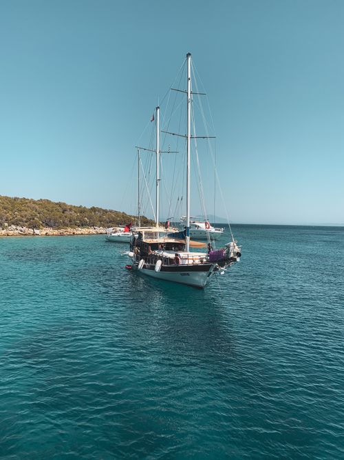 Free Serene view of sailing boats anchored in Bodrum's crystal clear waters, Türkiye. Stock Photo