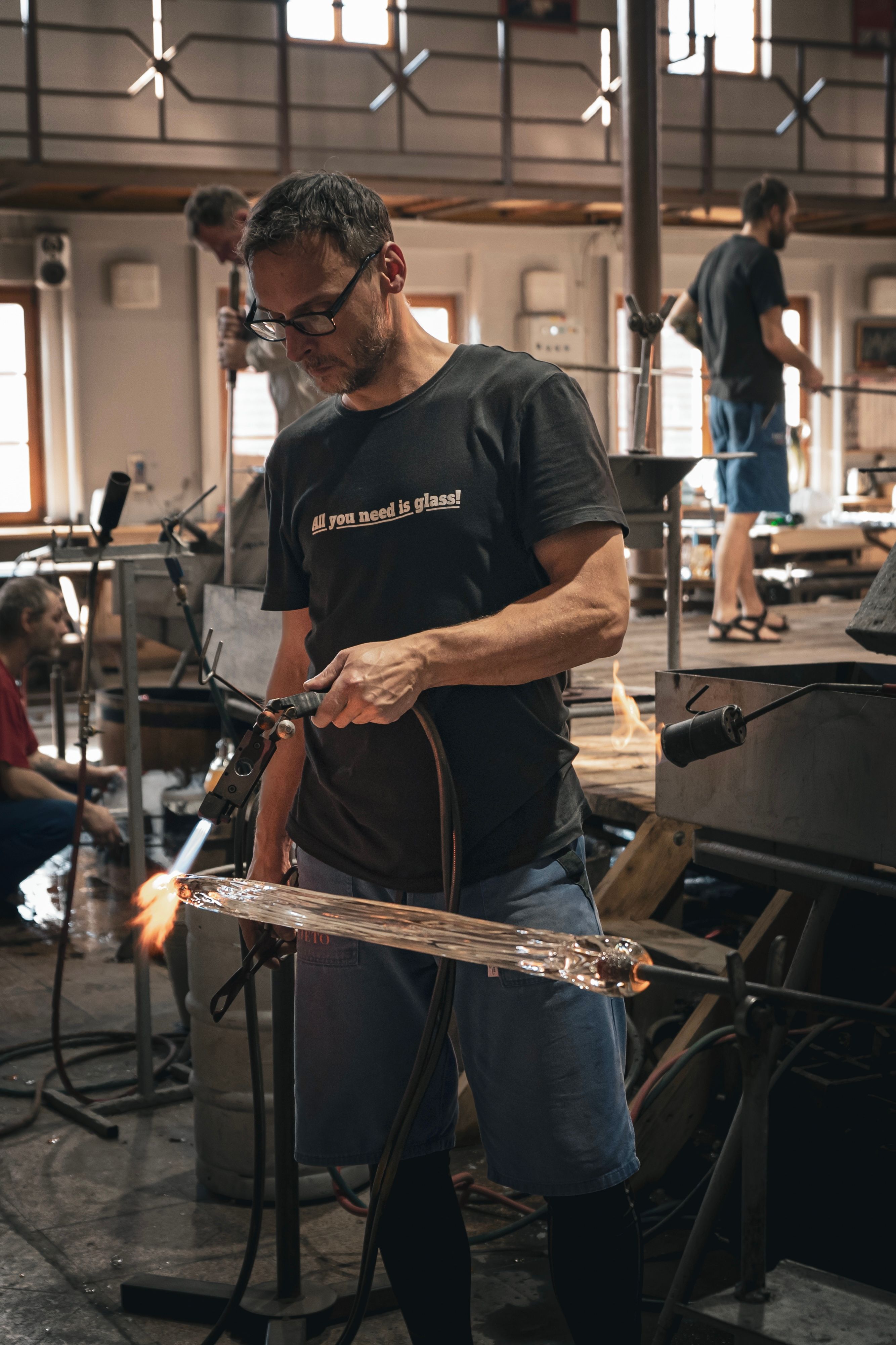 Glassblower works on molten glass piece in a Cvikov workshop, showcasing skill and tradition.