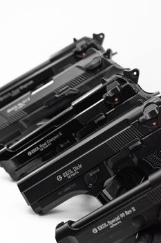 Detailed close-up of multiple black EKOL handguns arranged diagonally on a white background.