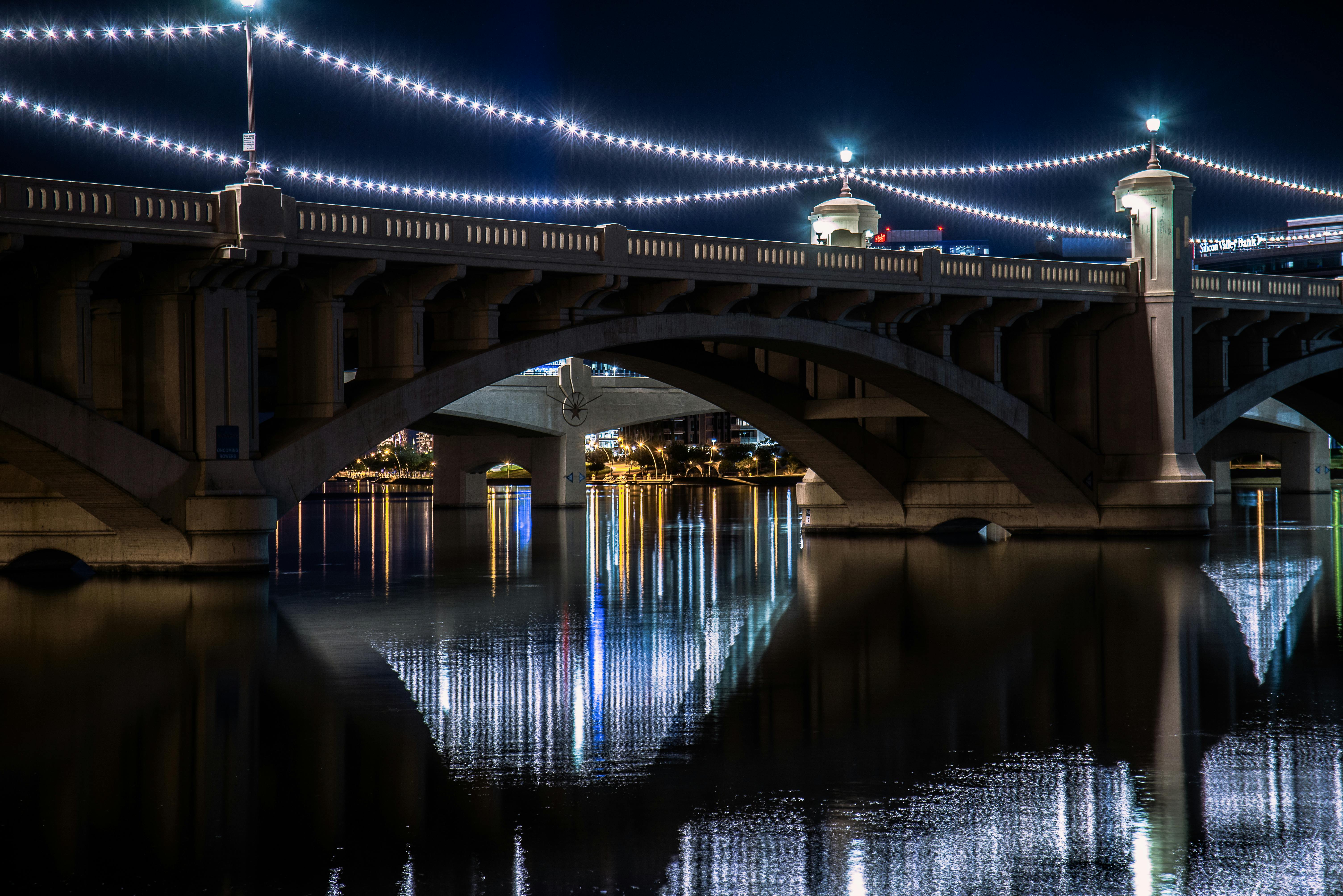 Stunning night view of the illuminated Tempe Town Lake Bridge, reflecting in the water.