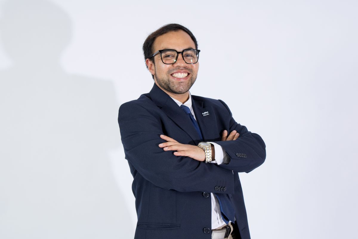 Professional businessman in a suit smiling confidently with arms crossed