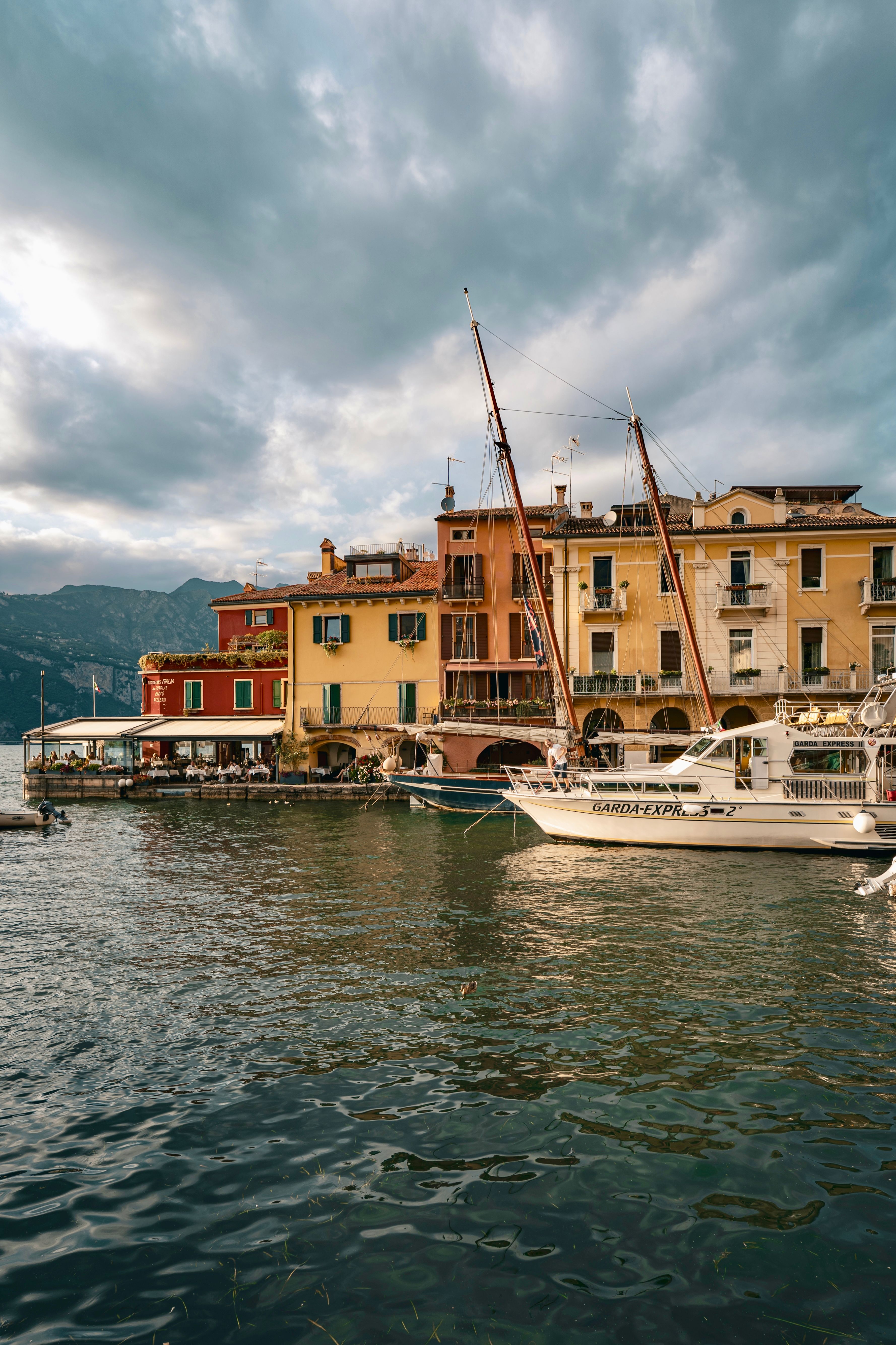 Picturesque view of Malcesine's waterfront with colorful buildings and sailboats.
