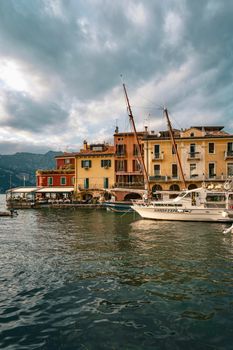 Picturesque view of Malcesine's waterfront with colorful buildings and sailboats.