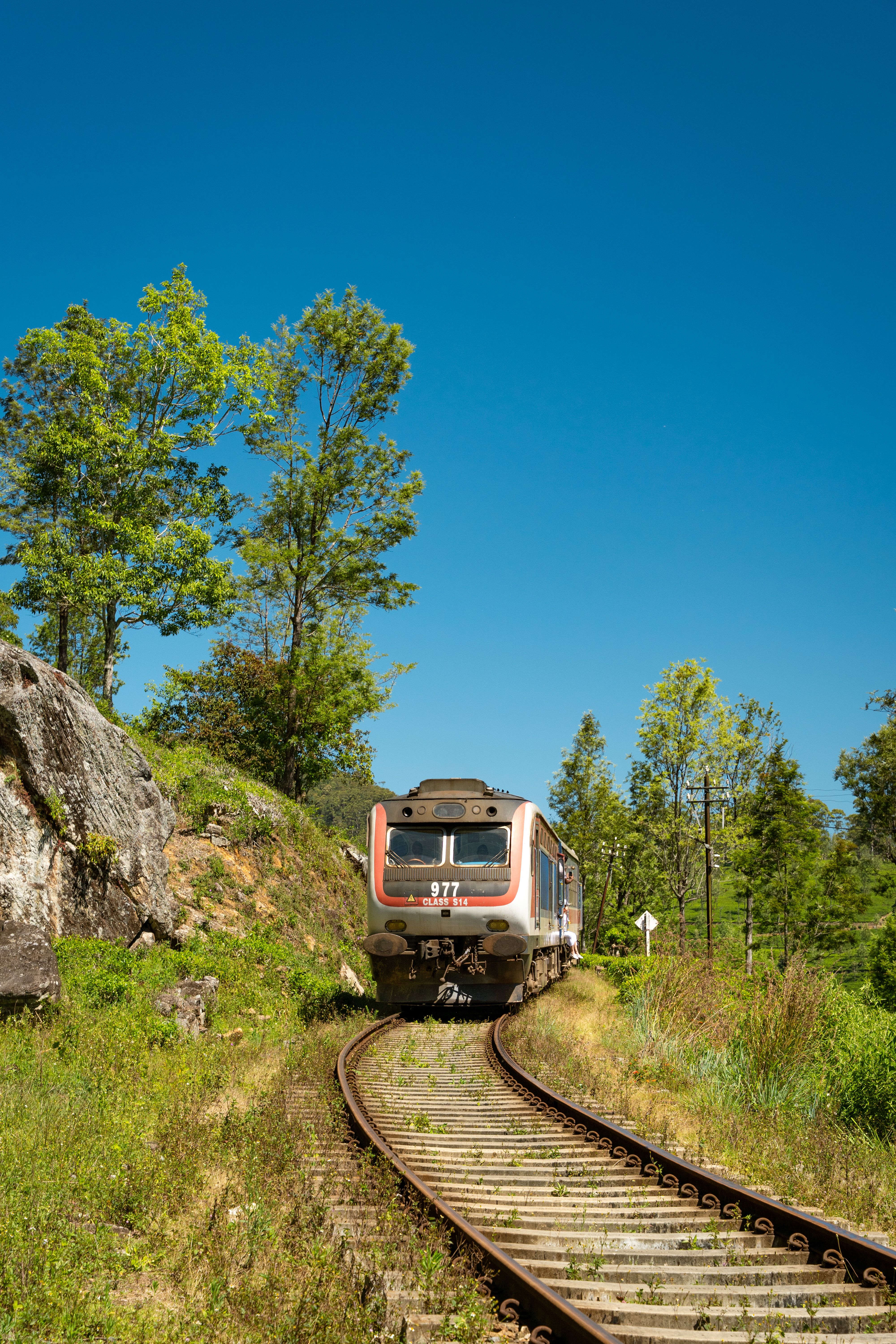 A train traveling through lush landscapes on a scenic railway in Sri Lanka.